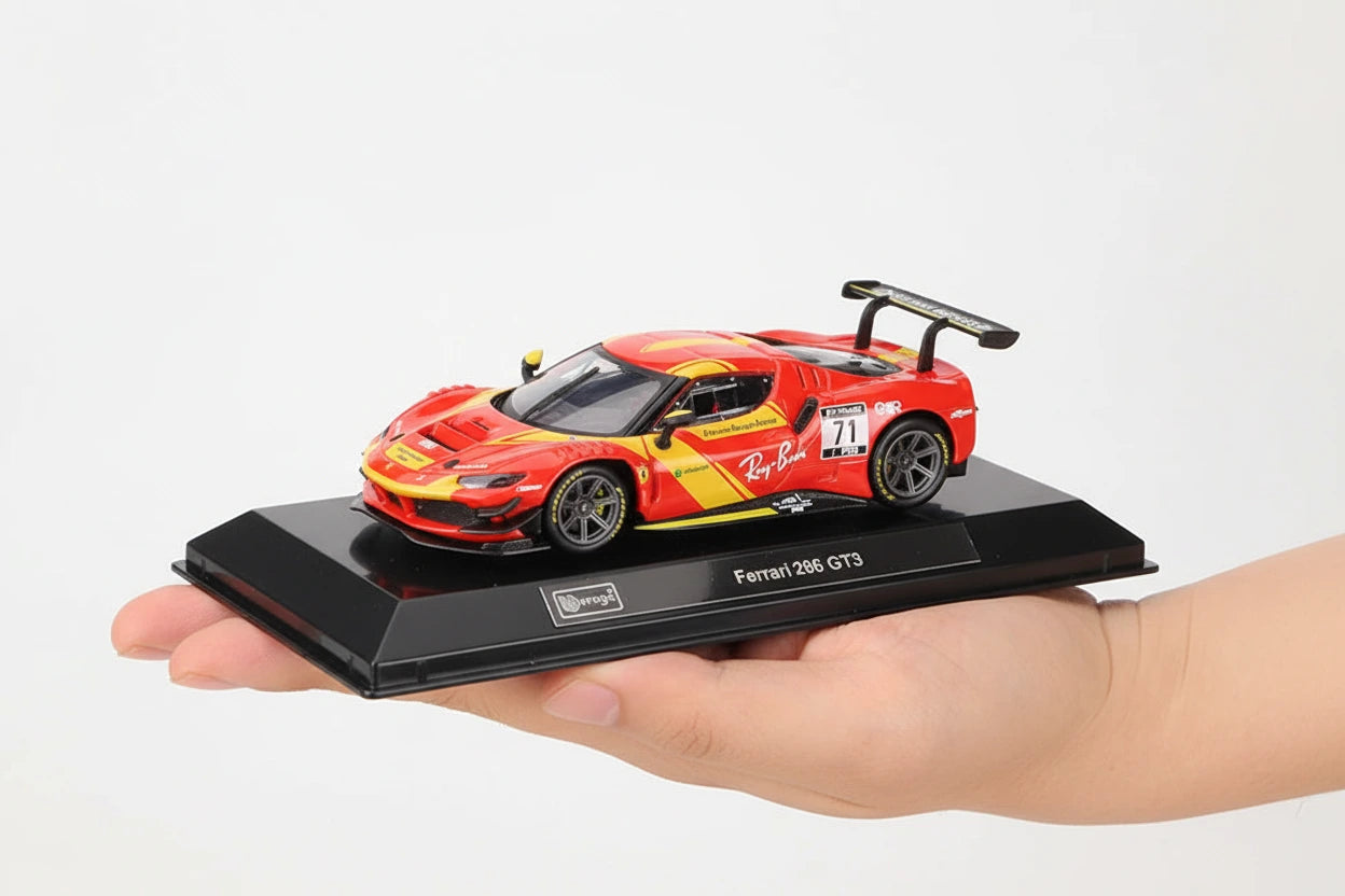 Model car of Ferrari 296 GT3 on a black display stand held by a hand against a dark background